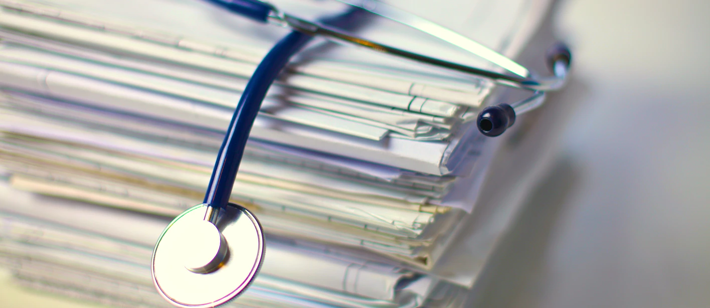 An image of a stethoscope on top of a pile of papers.